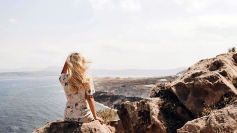 femme-confiante-regardant-horizon-sur-falaise-bord-de-mer